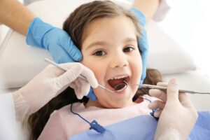 Dentist examining girl's teeth